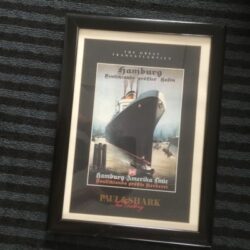 Framed poster of the Titanic ship displayed on a wall.