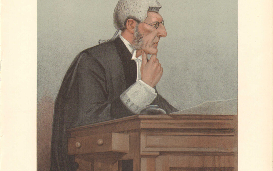 A man with white hair sitting at a wooden desk.
