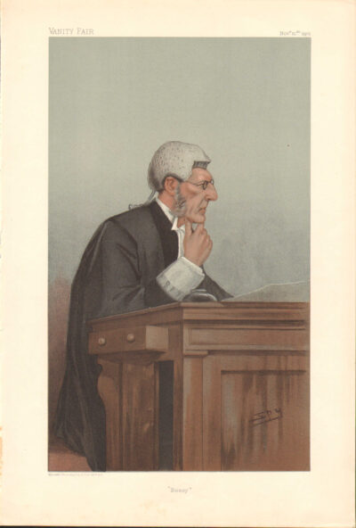 A man with white hair sitting at a wooden desk.